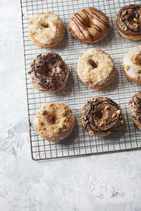 High angle view of donuts on cooling rack over table