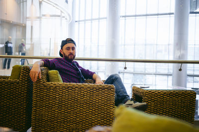 Portrait of young man sitting on armchair