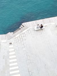 High angle view of woman sitting by swimming pool