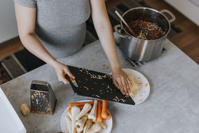 Mid section of woman preparing food, high angle view