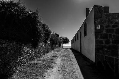 Footpath amidst buildings against sky