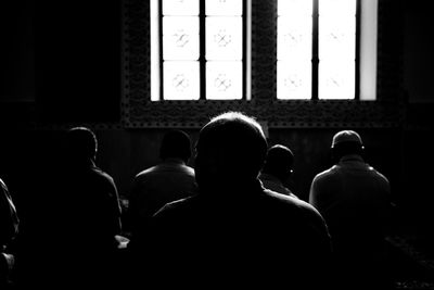 Rear view of people sitting in window