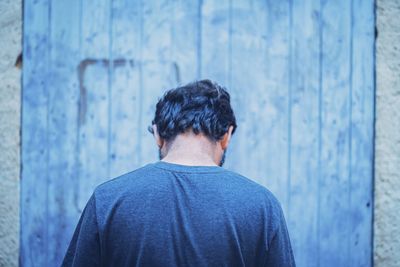 Rear view of man looking at camera