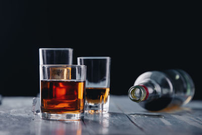 Close-up of beer glass on table against black background
