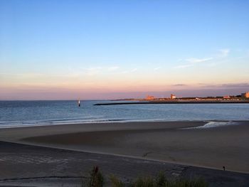 Scenic view of beach against sky during sunset