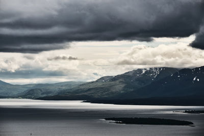 Scenic view of sea by mountains against sky in tromso