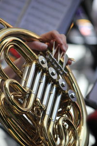 Cropped image of person playing french horn