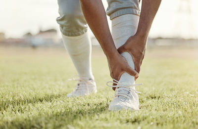 Low section of man running on field