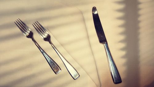 High angle view of forks with knife on table