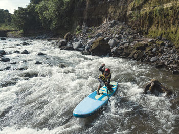 Man paddle boarding the river