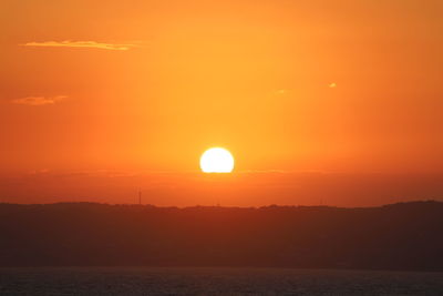 Scenic view of sea against romantic sky at sunset