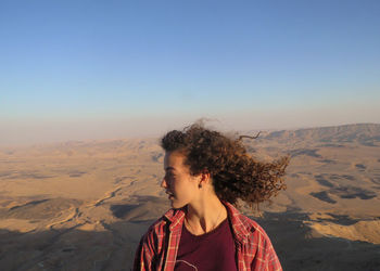 Woman on arid landscape against sky