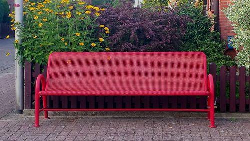 Red chairs against trees and plants