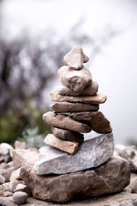 Stack of stones on rock against sky