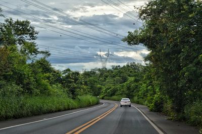 Road amidst trees against sky