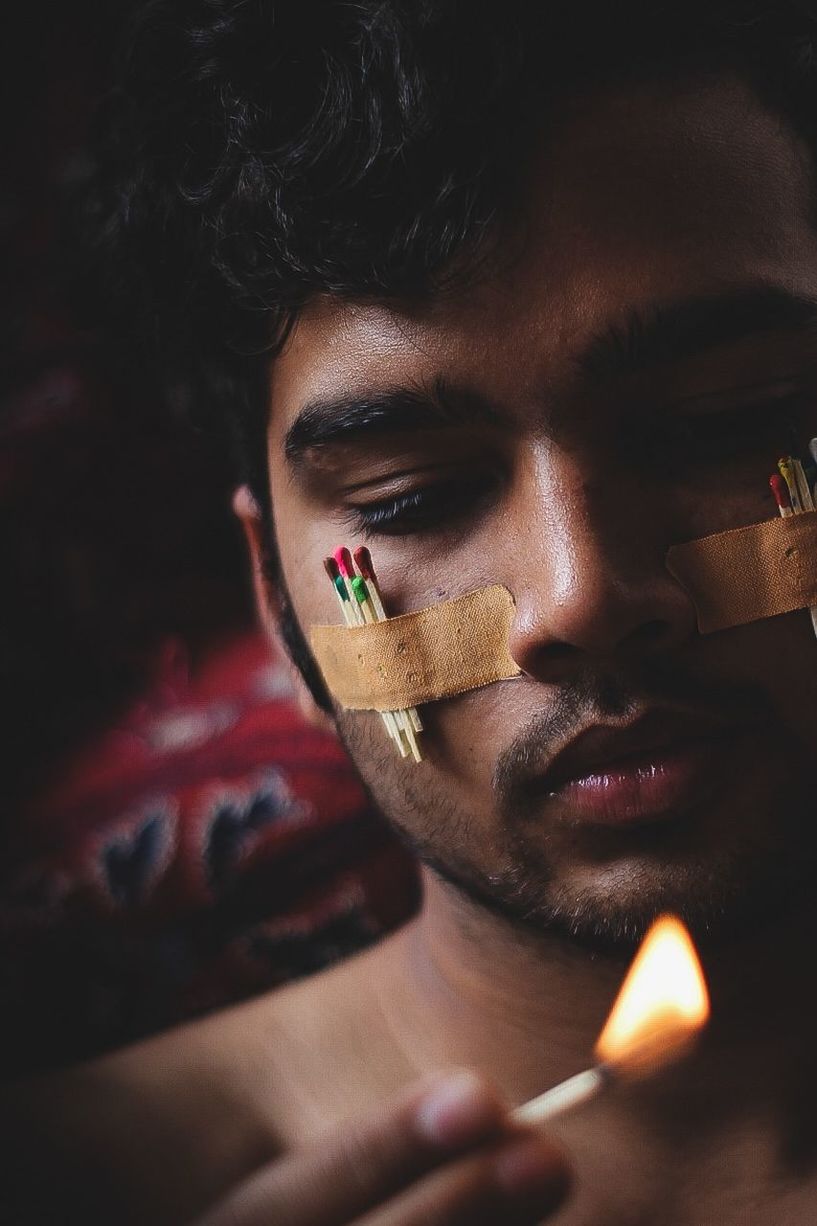 one person, headshot, close-up, young adult, portrait, young men, real people, indoors, social issues, lifestyles, front view, leisure activity, smoking issues, men, warning sign, cigarette lighter, communication, activity, human face