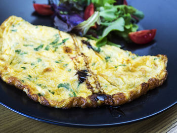 High angle view of omelet and vegetables served in plate on table