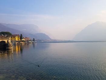 Mist at sunset over the blue lake como and mountains, lombardy italy 