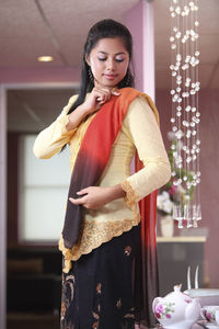 Woman wearing traditional clothing at home