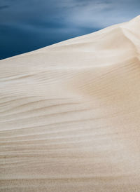 Sand dune on beach against sky