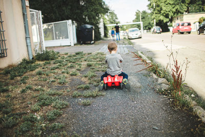 Rear view of boy on road in city