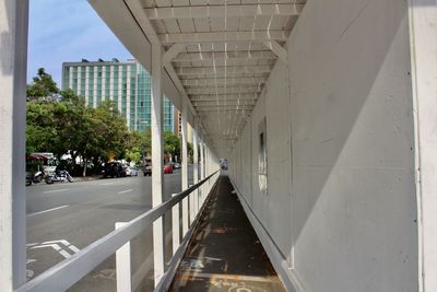 Bridge over road amidst buildings in city