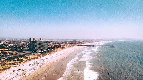 High angle view of sea and buildings against clear sky