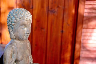 Close-up of buddha statue against temple