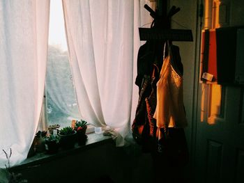 Close-up of clothes hanging on window at home