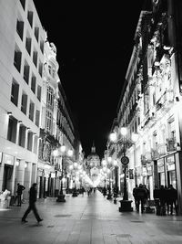 People on illuminated street at night