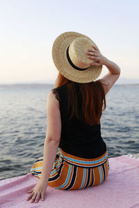 Rear view of woman with hat on beach