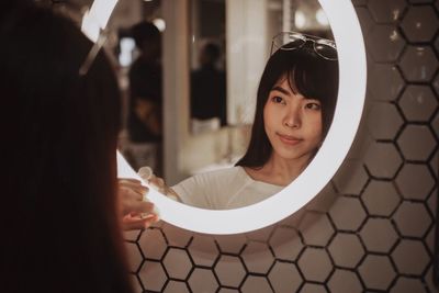 Portrait of woman with reflection in mirror