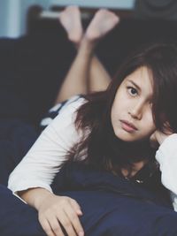 Portrait of beautiful woman lying on bed