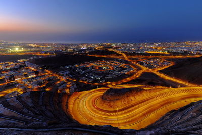 High angle view of city lit up at night