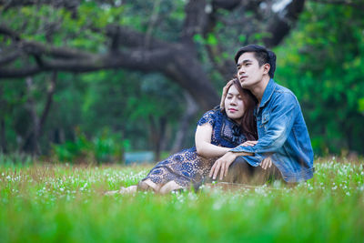 Full length of young couple on field