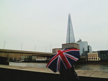 Rear view of woman with british flag umbrella against shard london bridge in city