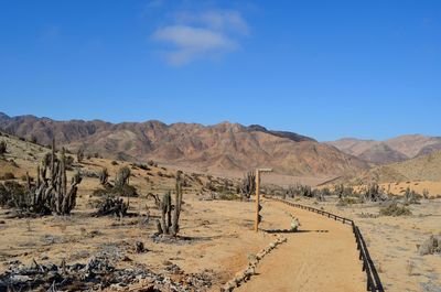 Scenic view of field and mountains against clear blue sky