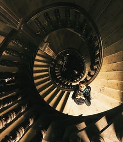 Directly above view of woman standing on spiral staircase