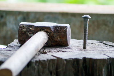 Close-up of hammer and nail on wood