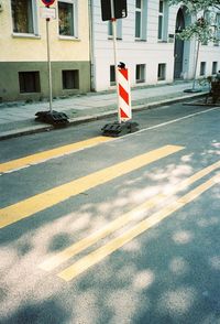 Road sign on street against buildings in city