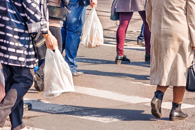 Low section of people walking on road