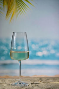 Closeup summer white wine glass on sand beach