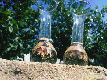 Low angle view of elderberry syrup in glass containers on sand
