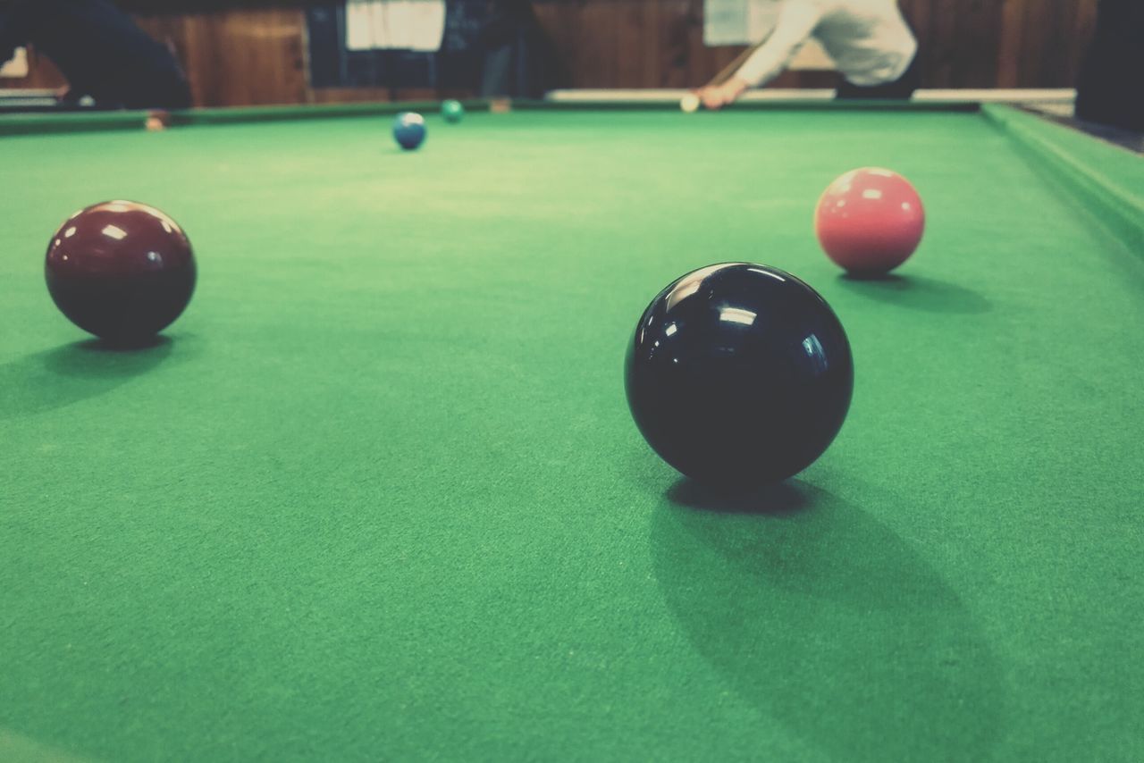 green color, sport, ball, close-up, circle, still life, toy, multi colored, grass, single object, selective focus, focus on foreground, childhood, table, high angle view, geometric shape, indoors, sphere, no people, competition