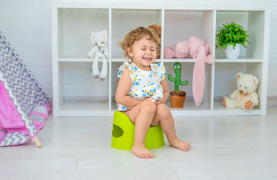 Portrait of cute girl playing with toys on floor