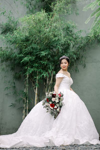 Portrait of woman standing against plants