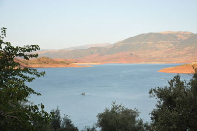 Scenic view of lake and mountains against clear sky