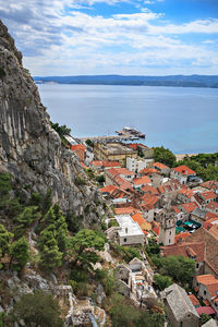 High angle view of townscape by sea against sky