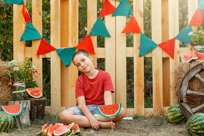 Happy boy sitting on multi colored umbrellas