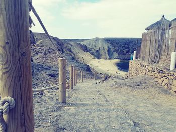 Panoramic shot of wooden post on landscape against sky